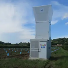 Un canon anti-grêle SPAG se dresse dans un vignoble, prêt à protéger les jeunes plants des orages.