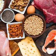 Assortiment d'aliments riches en fer : viande rouge, saumon, poulet, œufs, fromage, amandes, noix, pois chiches, haricots, graines de chia et cottage cheese.