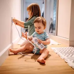 Deux enfants jouent avec des prises électriques, un danger potentiel d'électricité dans le corps.