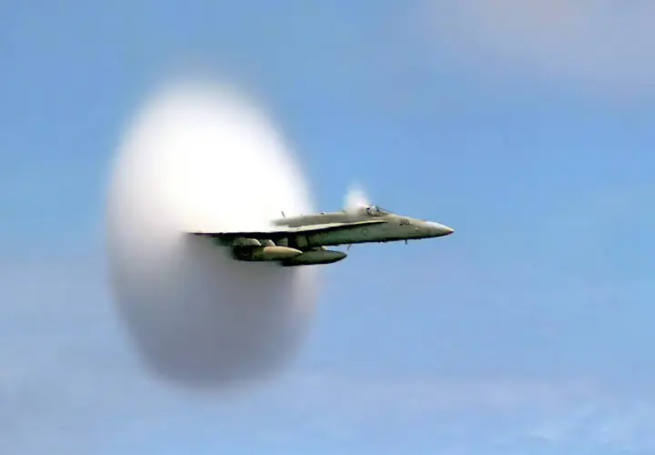 Un avion de chasse F/A-18 Super Hornet est capturé en plein vol, créant une impressionnante formation de nuages en passant le mur du son.