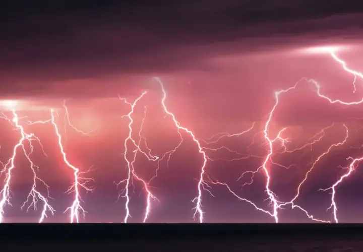 Un ciel orageux aux teintes roses et violettes, illuminé par un **éclair de chaleur** spectaculaire qui déchire l'horizon au-dessus de la mer.