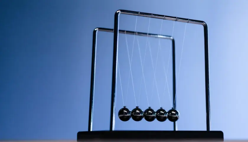 Un pendule de Newton, avec ses billes d'acier suspendues, illustre la conservation de l'énergie et de la quantité de mouvement. À quoi ça sert ? À observer la physique en action !