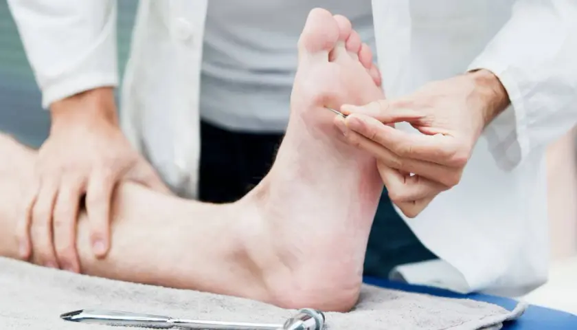 Un médecin teste la sensibilité d'un pied, suggérant un nouveau neuropathie traitement révolutionnaire.