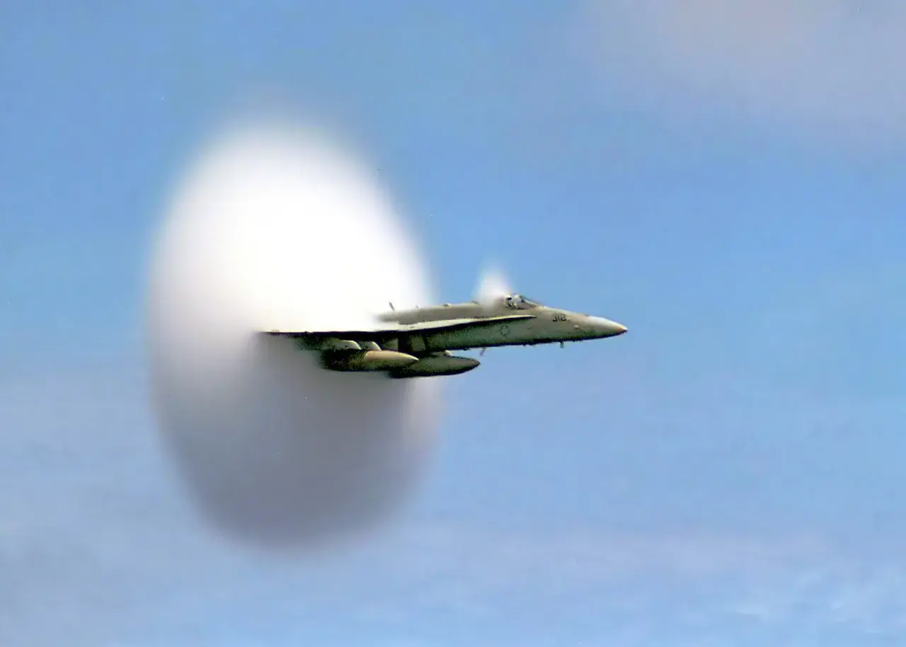Un avion de chasse F/A-18 Super Hornet est capturé en plein vol, créant une impressionnante formation de nuages en passant le mur du son.