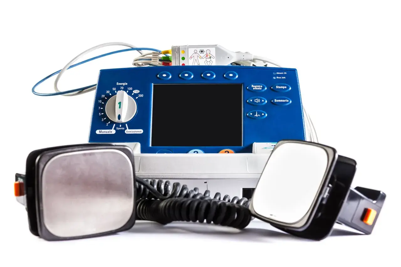 Défibrillateur bleu avec électrodes. La question "peut-on mourir avec un défibrillateur implanté" reste ouverte, mais cet appareil externe est conçu pour sauver des vies.
