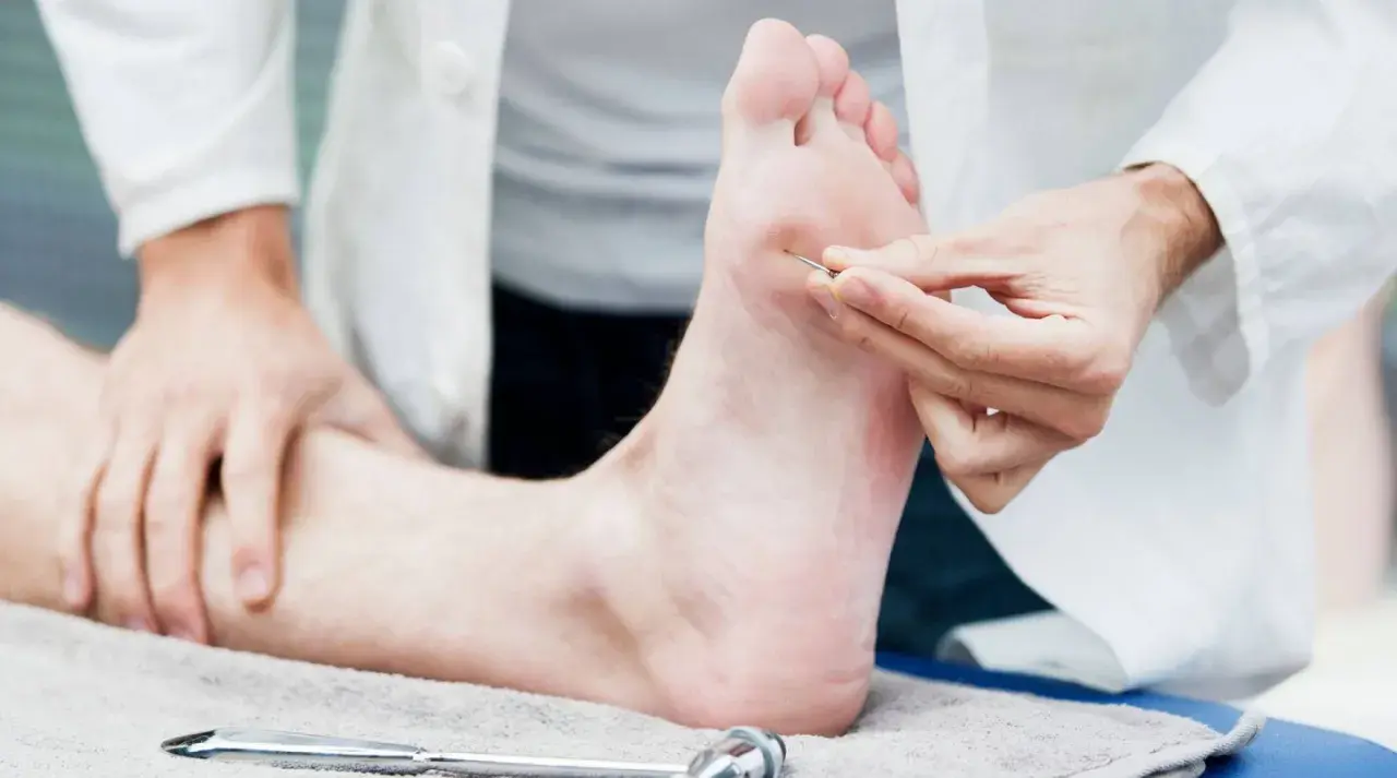 Un médecin teste la sensibilité d'un pied, suggérant un nouveau neuropathie traitement révolutionnaire.
