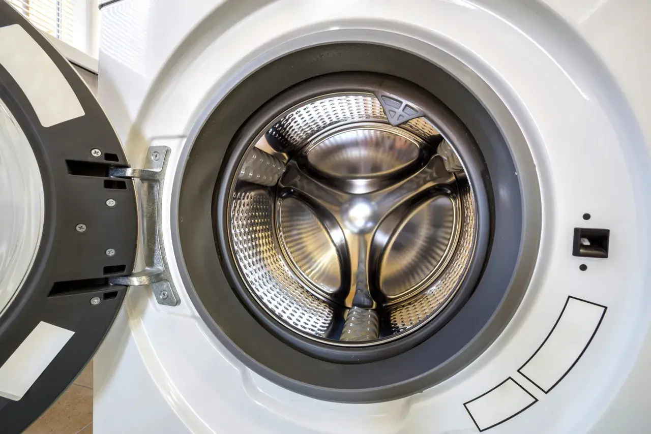 Tambour de machine à laver ouvert, prêt pour le linge. La force centrifuge lors de l'essorage le fera tourner à grande vitesse.
