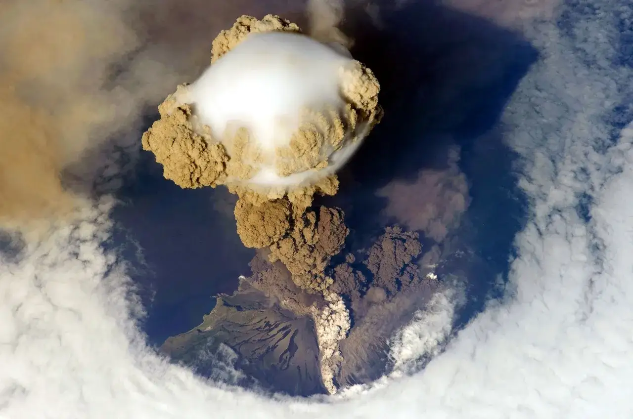 Éruption spectaculaire d'un volcan, projetant un panache de cendres et de fumée dans le ciel. On dirait que la nature a décidé de fabriquer un volcan.